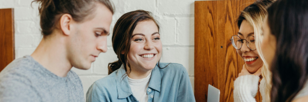 Image of three people smiling at each other in a meeting