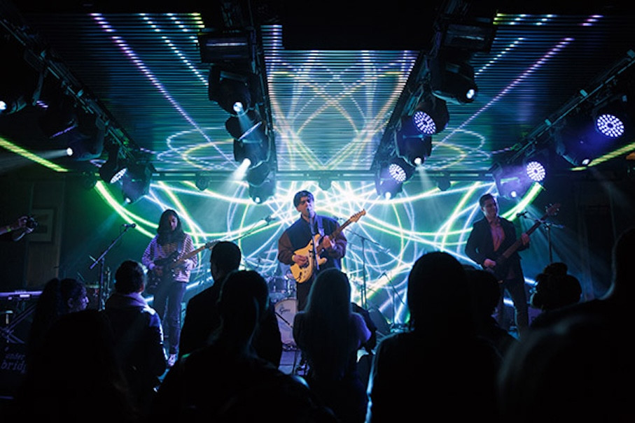 Band playing on stage with three guitarists