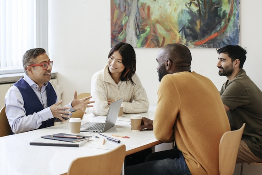 Colleagues seated around a table working collaboratively
