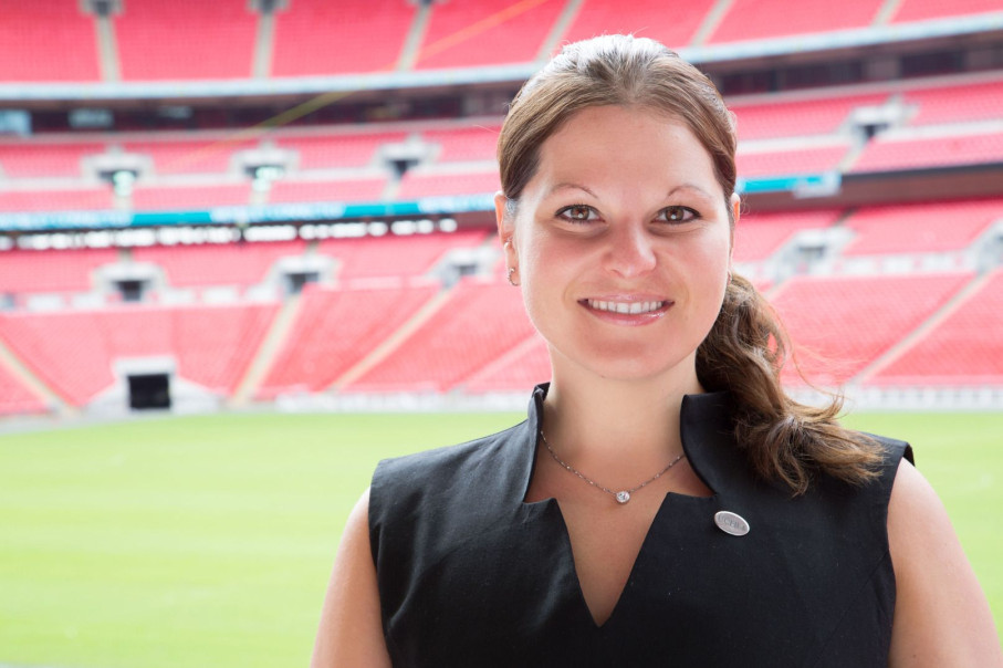 Sharona Friedman smiling to camera in front of a football stadium
