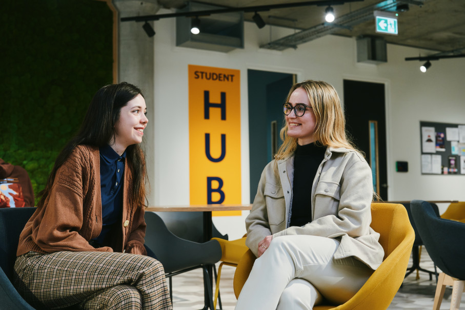 Female students seated in a student hub setting