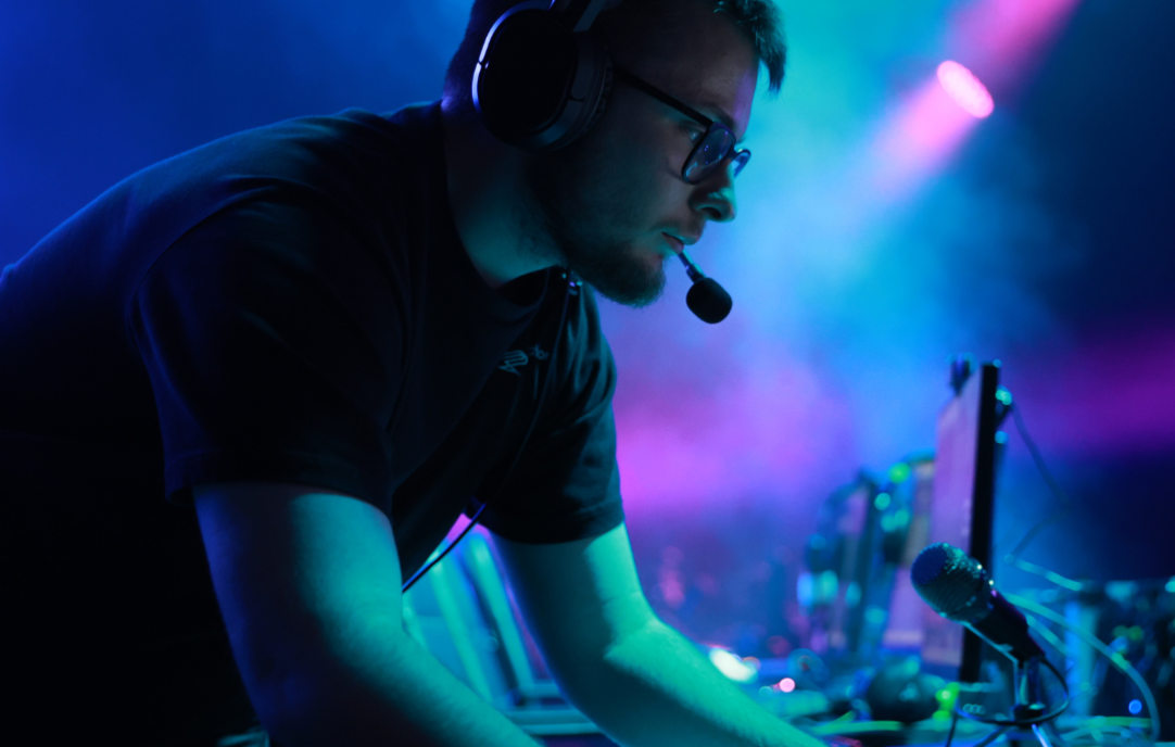Male at mixing desk with headphones