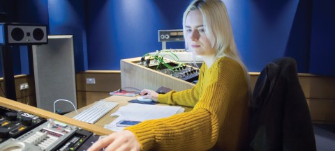 Girl in yellow jumper at mixing desk