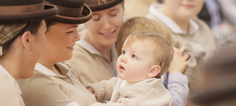 Norland nannies in brown hats, one holding a baby