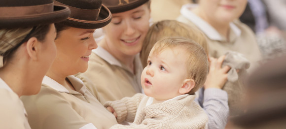 Norland nannies in brown hats, one holding a baby