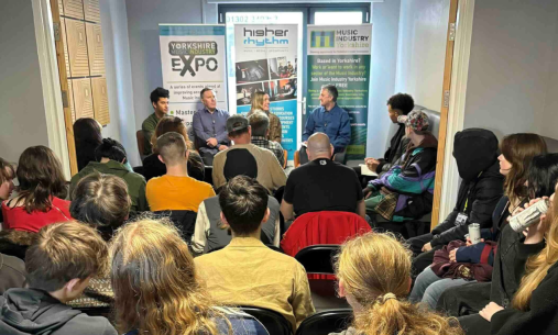 An audience in front of a panel at a Higher Rhythm Expo 