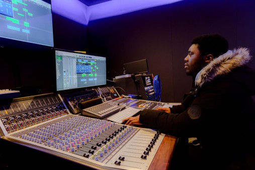 Male student using mixing desk and technology