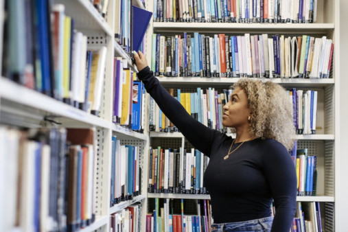 Student choosing a book in library