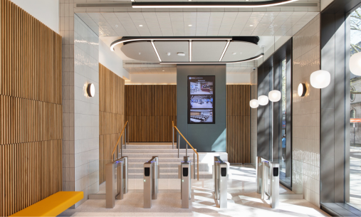 Entrance of NYU London is wooden and cream with metal barriers