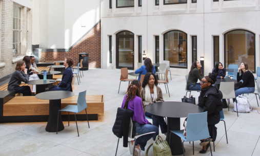 NYU London students sitting in a white stone courtyard