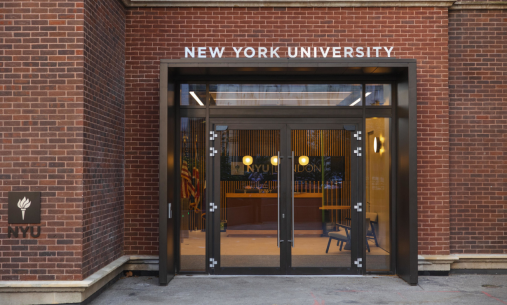 NYU London outdoor entrance. A brick wall with clear doors that say New York University