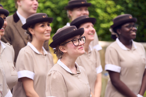 Norland nannies in uniform of beige tops and brown hats
