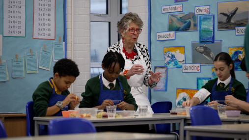 Prue Leith is in a primary school teaching children how to cook.
