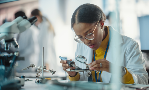 One student looking through a magnifying glass