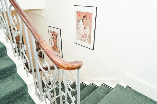 A stairway with Vogue covers along the walls
