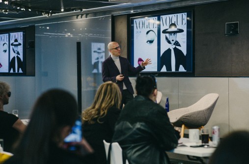 A teacher presenting Vogue drawings to a group of students in a classroom